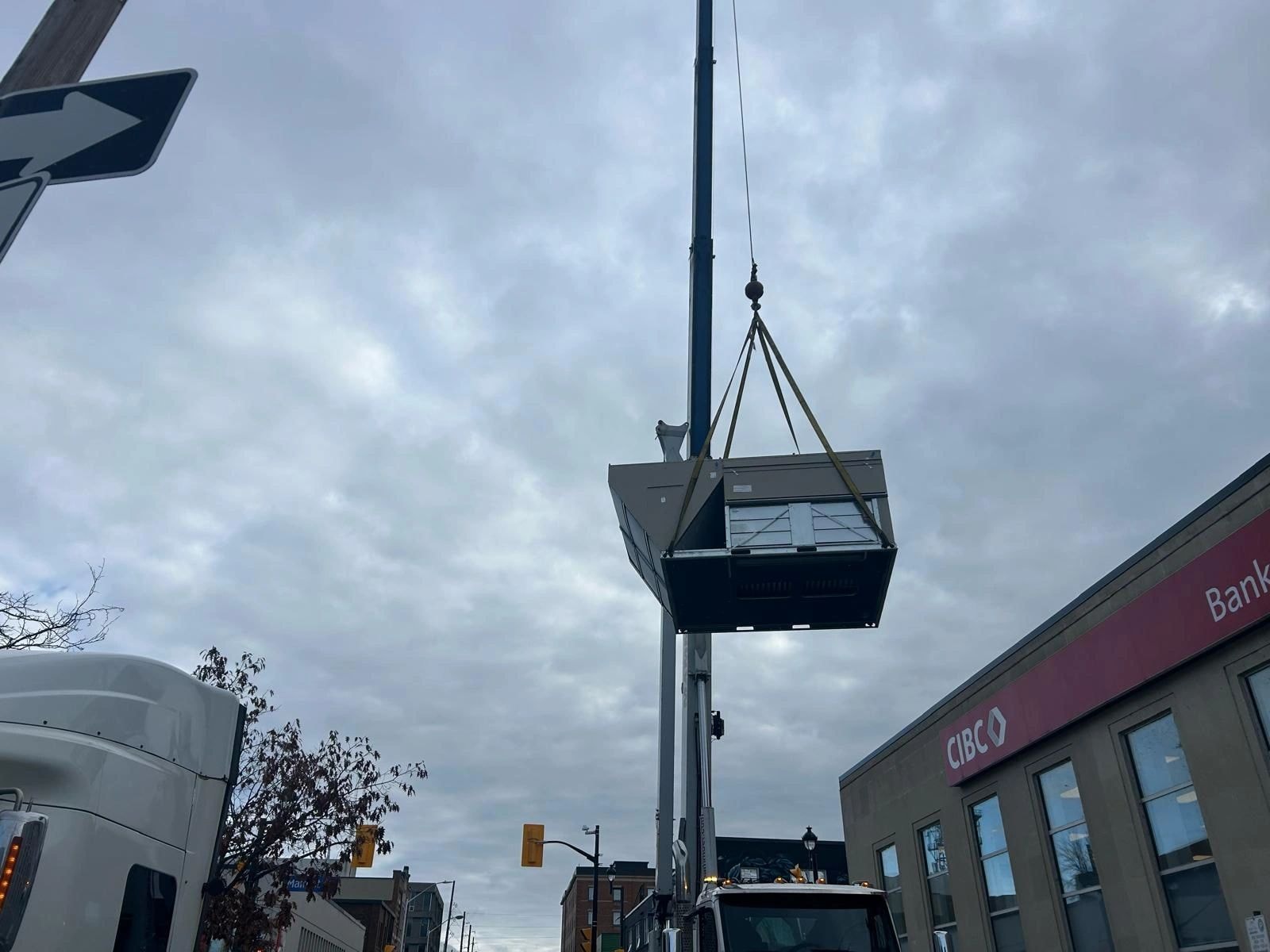 Crane lifting HVAC unit urban installation